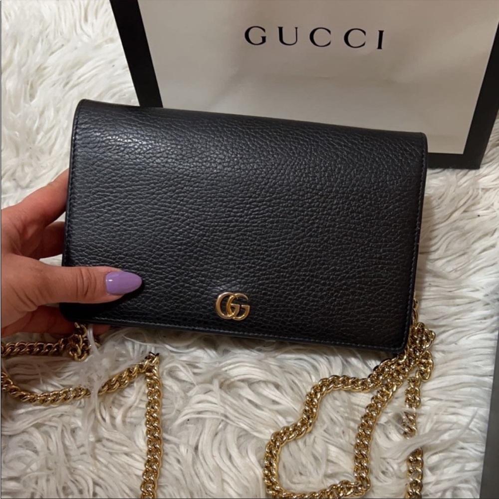 Black gucci purse with gold chain. Worn only 4 times. Still New And  Clean.
